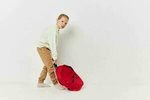 retrato de contento sonriente niño niña rojo mochila elegante ropa ligero antecedentes foto