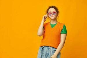 beautiful woman orange sweatshirts sunglasses multicolored glasses supply yellow background unaltered photo