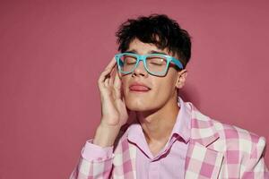 A young man fashionable glasses pink blazer posing studio pink background unaltered photo