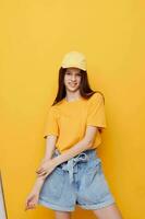 foto bonito mujer posando en un amarillo camiseta y gorra aislado antecedentes