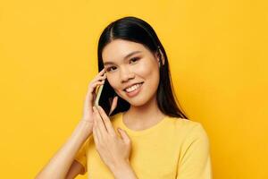 Charming young Asian woman communicates on the phone emotions studio model unaltered photo
