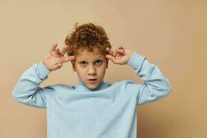 curly boy in a blue sweater posing fun childhood unaltered photo