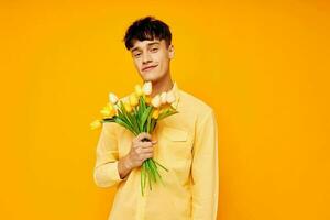 handsome guy in yellow glasses with a bouquet of flowers yellow background unaltered photo