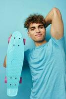 kinky guy skateboard in hand in blue t-shirts isolated background photo