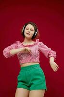 cheerful woman in green shorts listening to music on headphones photo