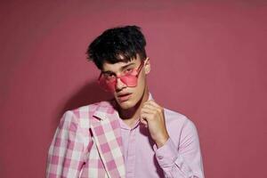 A young man self confidence pink plaid blazer fashion posing pink background unaltered photo