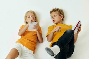 Cute stylish kids lie on the floor with notepads and pencils childhood lifestyle unaltered photo