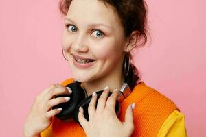 funny girl in an orange jacket headphones music entertainment Lifestyle unaltered photo