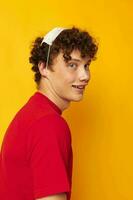 guy with red curly hair wearing a red t-shirt medical mask on the face posing yellow background unaltered photo