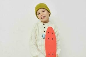 Portrait of happy smiling child girl stylish clothes skateboard light background photo