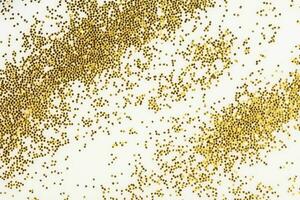 Festive or glamorous background. Gold sparkles scattered on a white background. photo