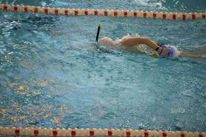 niño atleta nada en el piscina. nadando sección. foto