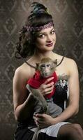 Retro female portrait in the style of 20s or 30s. A gorgeous lady is holding a little monkey. photo