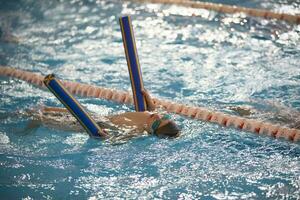 Child athlete swims in the pool. Swimming section. photo