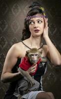 Retro female portrait in the style of 20s or 30s. A gorgeous lady is holding a little monkey. photo