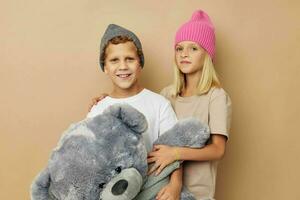 Boy and girl in hats with a teddy bear friendship Lifestyle unaltered photo