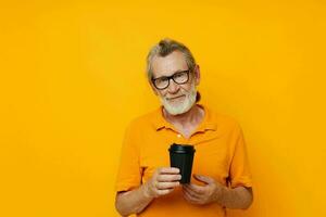 Portrait of happy senior man with black disposable cup isolated background photo