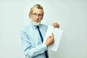 mayor canoso hombre participación documentos con un sábana de papel ligero antecedentes foto