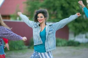 contento mujer en un mezclilla chaqueta es baile. mujer en el estilo de el años 90 foto