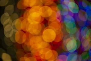 Multi-colored large bokeh spots of blue, yellow and orange. Bokeh from a Christmas garland. photo