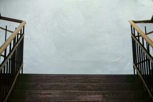 Wooden old staircase and light concrete wall. photo