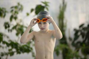 chico en un nadando gorra en el Deportes piscina. foto