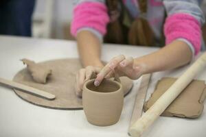Clay modeling workshop. Hands make an earthenware cup. photo
