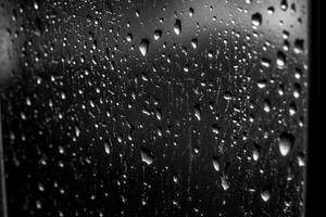 Water drops on a window glass in black and white. Abstract background photo