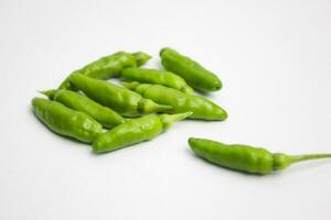 a pile of green chili peppers on a white background photo