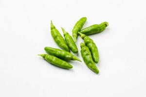 a pile of green chili peppers on a white background photo