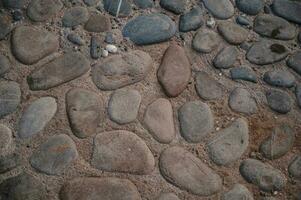 Decorative path made of natural small pebbles. Image of a part of a walking path. Close-up photo