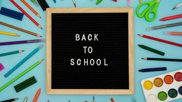 Text Back to school soon on a wooden letter board. buying stationery, flatlay, bright background. Autumn school fees. photo