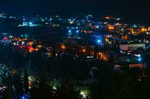 noche paisaje. ver de el noche ciudad en un montañoso área. pequeño pueblo foto