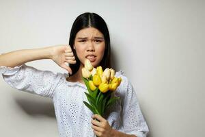 encantador joven asiático mujer con un ramo de flores de flores sonrisa de cerca ligero antecedentes inalterado foto