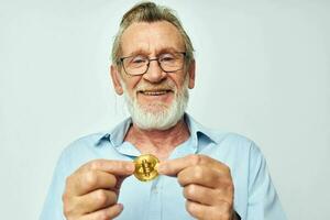 Photo of retired old man finance gold coins bitcoin posing isolated background
