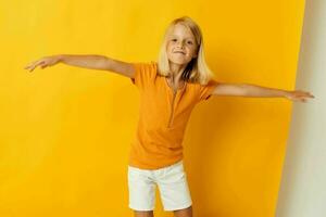 Little girl smile hand gestures posing casual wear fun yellow background unaltered photo