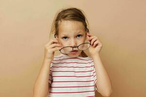 linda pequeño niña redondo lentes posando beige antecedentes foto