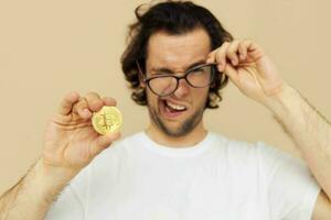 handsome man with glasses gold bitcoin in hands Lifestyle unaltered photo
