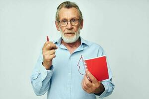 retrato de contento mayor hombre escribe abajo emociones en un cuaderno ligero antecedentes foto