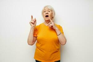 Portrait of an old friendly woman in casual t-shirt gestures with his hands cropped view photo