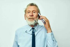 retrato de contento mayor hombre en un camisa con un Corbata con un teléfono tecnología recortado ver foto