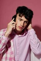 portrait of a young man plaid blazer fashion modern style talking on the phone model studio photo
