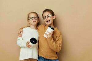 dos pequeño muchachas desechable lentes posando beige antecedentes foto