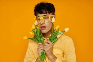 hermoso chico con un ramo de flores de flores posando un regalo aislado antecedentes inalterado foto