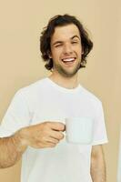 handsome man with a white mug in his hands emotions posing beige background photo