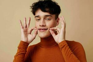 retrato de un joven hombre marrón suéter tipo con cuello de tortuga posando Moda aislado antecedentes inalterado foto