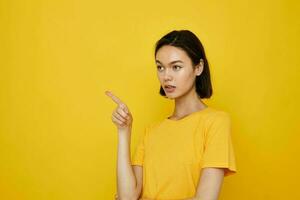 short haired brunette in yellow t-shirt posing fashion yellow background photo