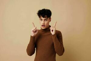 portrait of a young man stylish hairstyle brown turtleneck light background unaltered photo