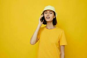 beautiful girl yellow t-shirt and Hat summer style with phone Lifestyle unaltered photo