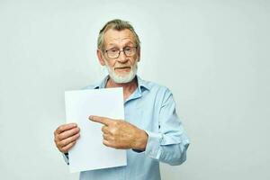 Portrait of happy senior man holding a sheet of paper copy-space posing isolated background photo